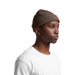 as colour cable beanie in army colour worn by a male model looking into the distance pondering life's greatest questions